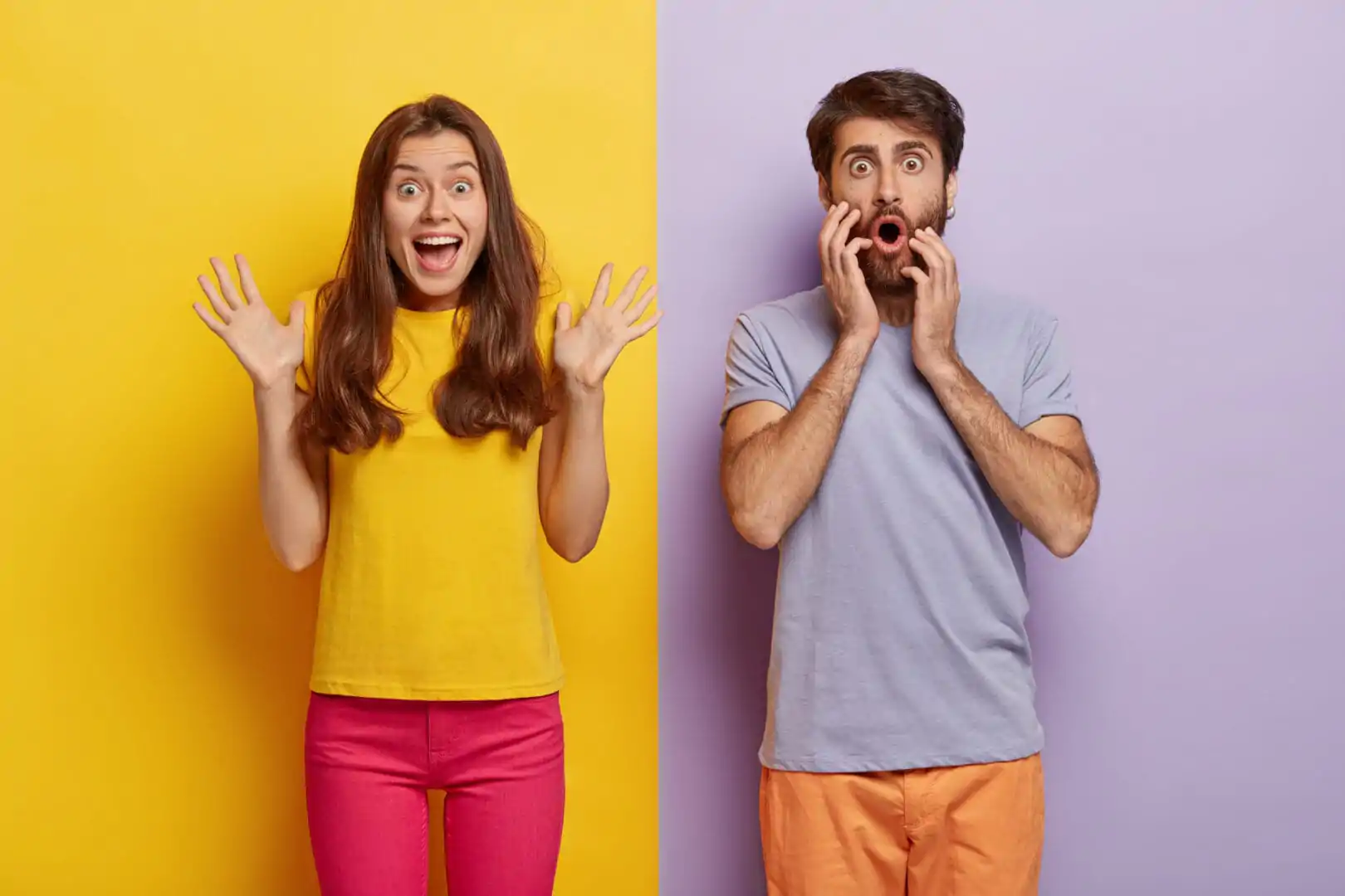 Photo of cheerful excited woman raises hands and exclaims something emotionally, shocked man stares with great wonder, dressed casually, stand against of two colored background. Emotions and people Propuesta de valor