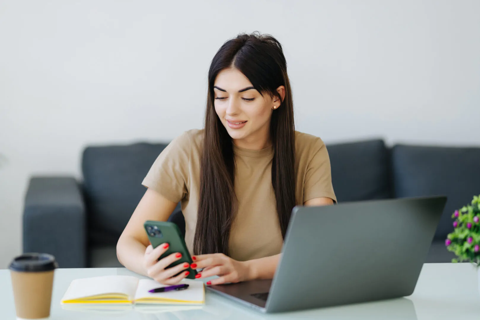 Woman using her cellphone, working from home office NOM 037